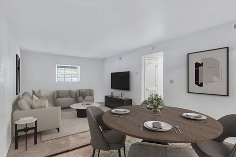 A modern dining room with a round table set for two.