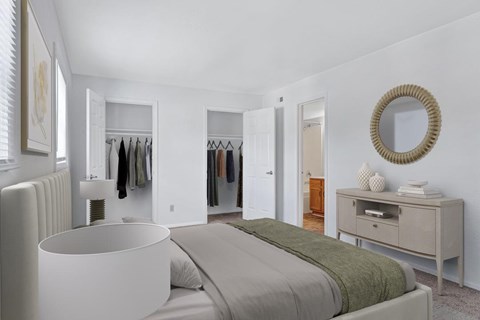 A bedroom with a bed, a dresser, and a mirror.