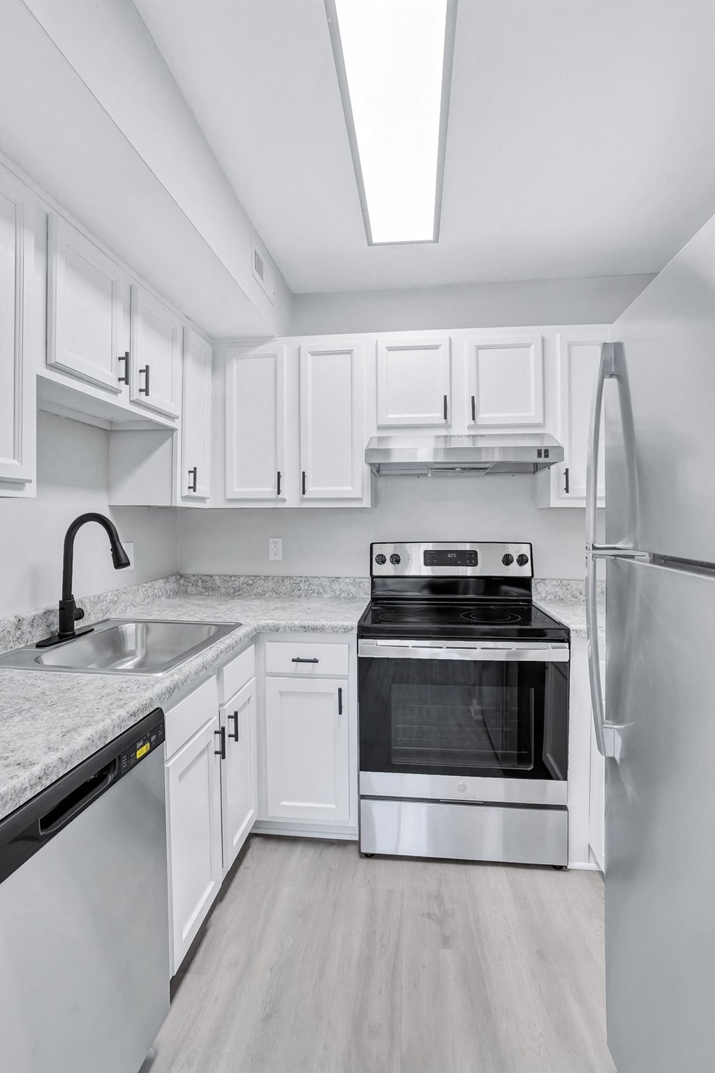 a kitchen with white cabinets and stainless steel appliances