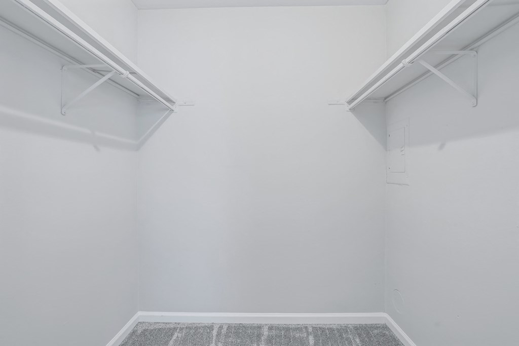 an empty room with white walls and two white shelves on the wall