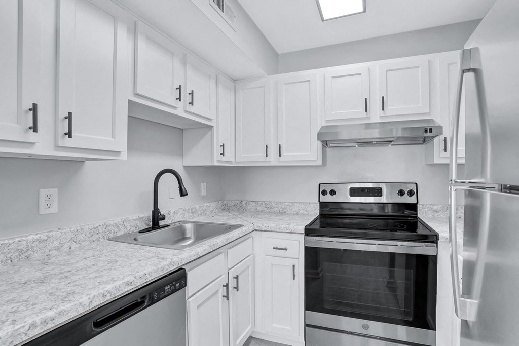 a kitchen with white cabinets and black appliances