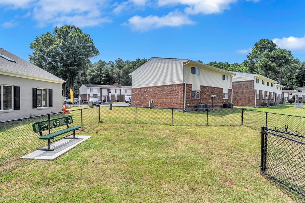 our apartments have a fenced in yard with a park bench