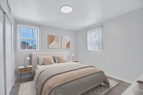 A bedroom with a large bed and a window with blinds.