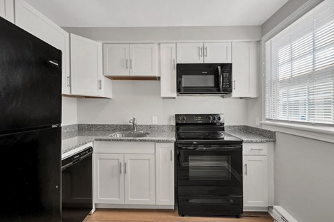a kitchen with black appliances and white cabinets