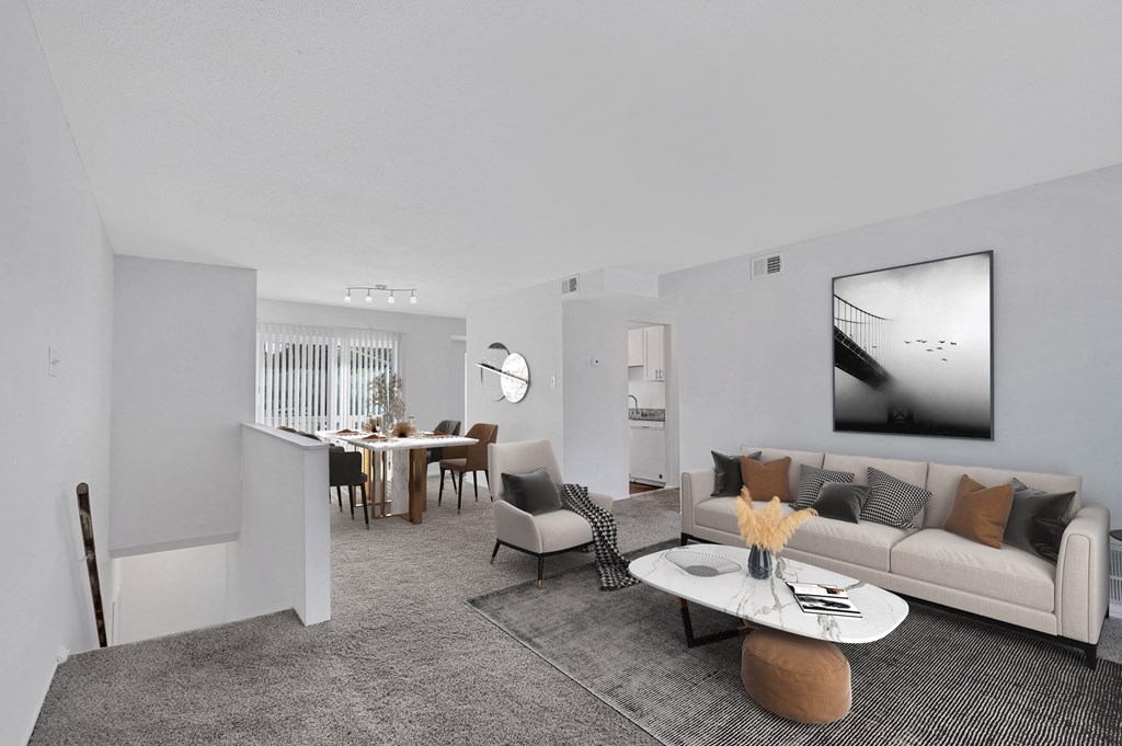 a living room with white walls and grey carpet