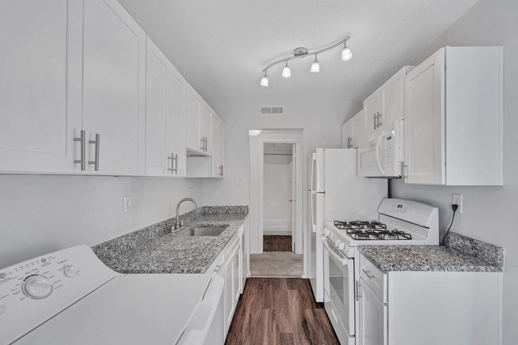 a white kitchen with white appliances and white cabinets