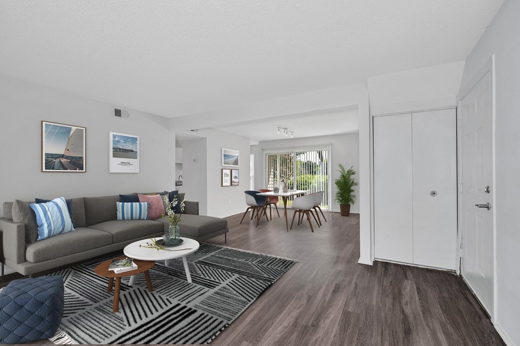 a living room with a grey couch and a black and white rug