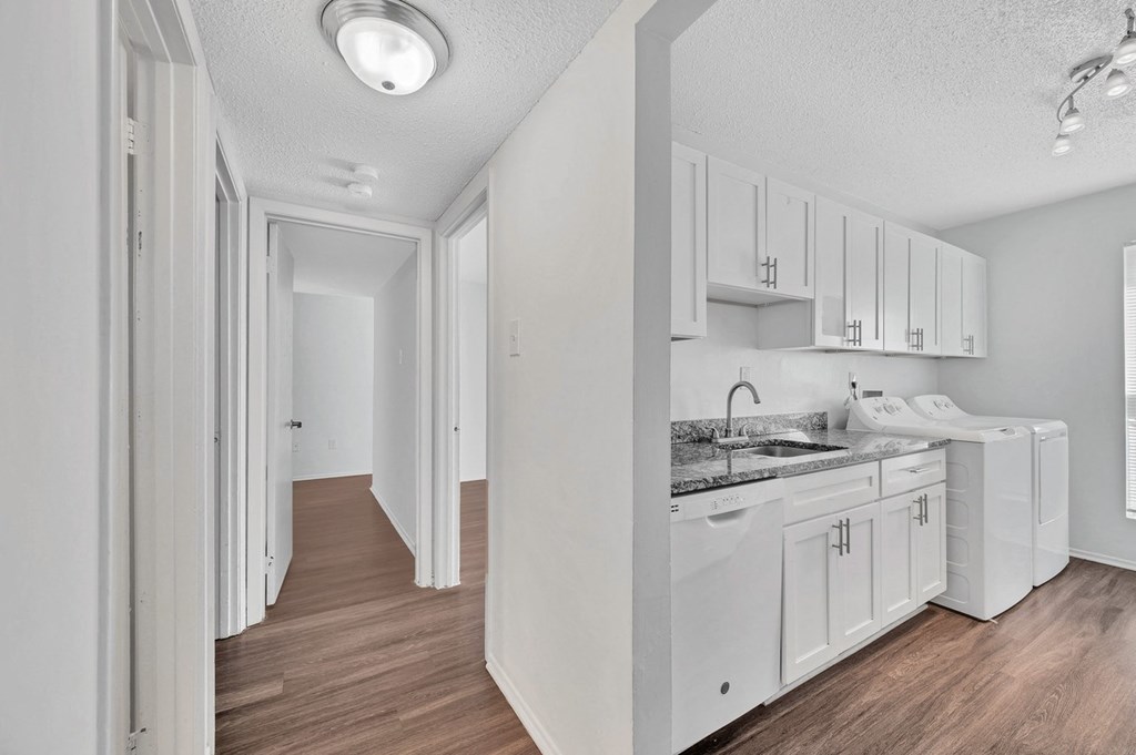 a white kitchen with white cabinets and white appliances