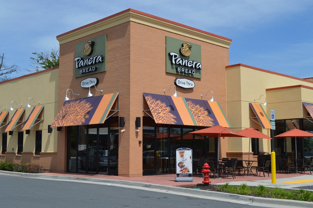 the front of a restaurant with umbrellas and tables