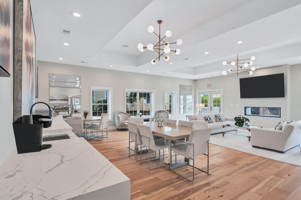 a clubroom with white sofas, a dinette, and are on the walls.