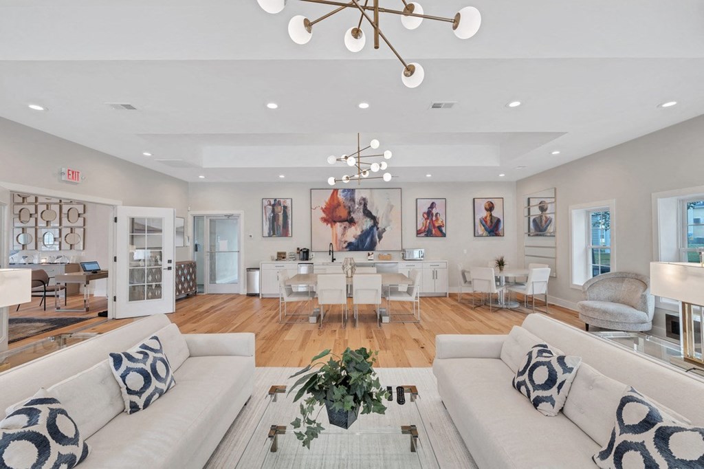 a clubroom with white sofas, a dinette, and are on the walls.