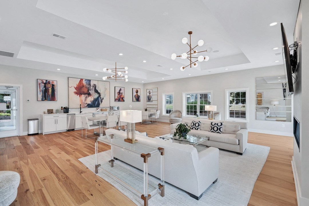 a clubroom with white sofas, a dinette, and are on the walls.