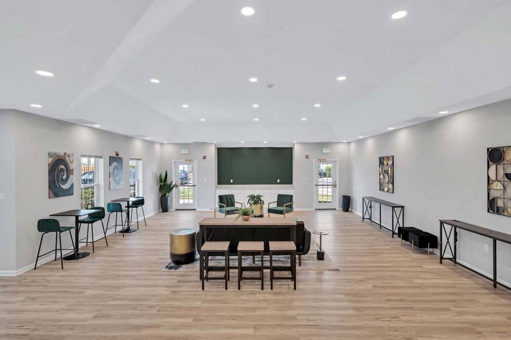 a large room with a large table and chairs and a blackboard on the wall