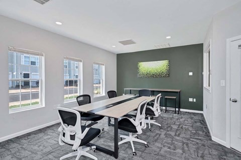 a conference room with a table and chairs and a tv on the wall