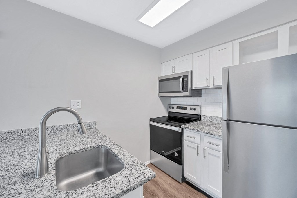 a kitchen with granite countertops and stainless steel appliances