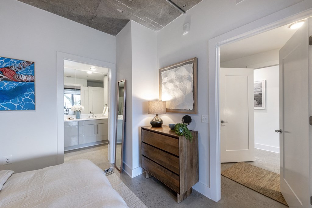 a bedroom with a bed and a dresser and a bathroom