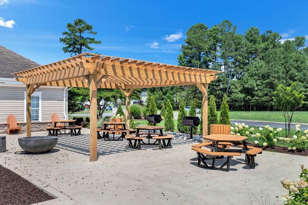a wooden pavilion with benches and tables