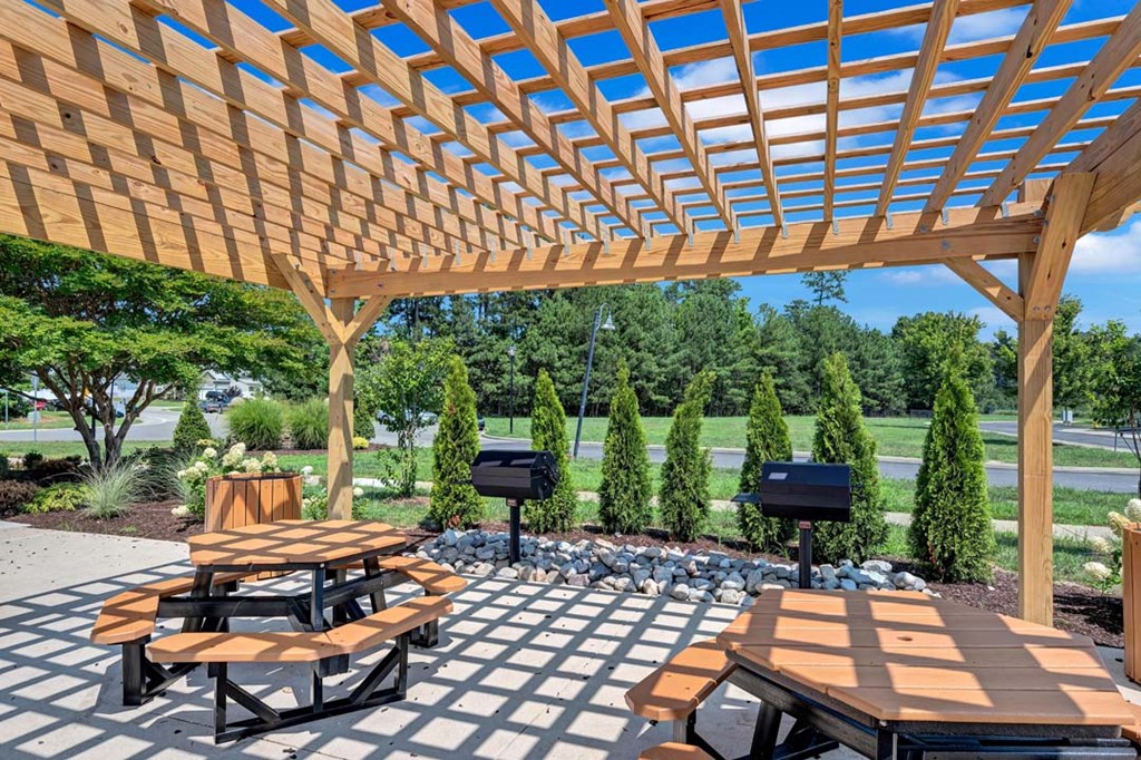 a wooden pergola with benches and tables