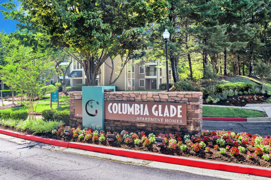 a sign for the columbia glade amusement park in front of a garden