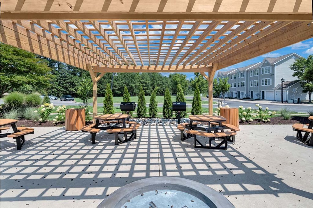 a picnic area with a grill and picnic tables