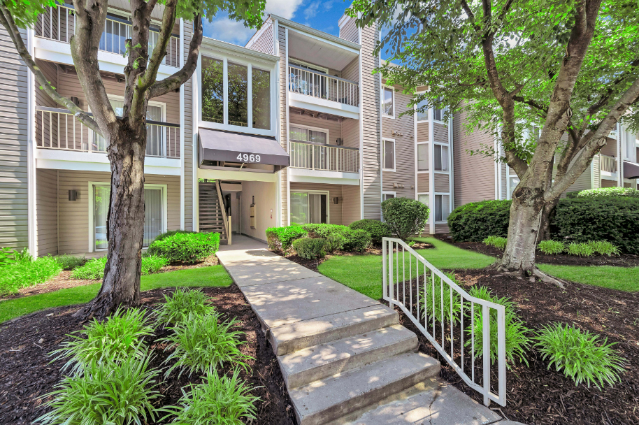 a stairway leading up to an apartment building with trees