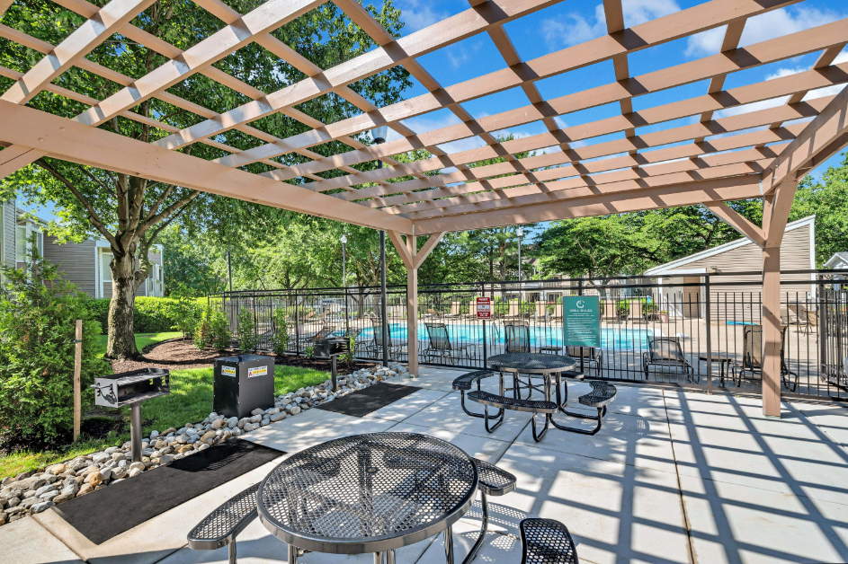a patio with tables and chairs and a pool