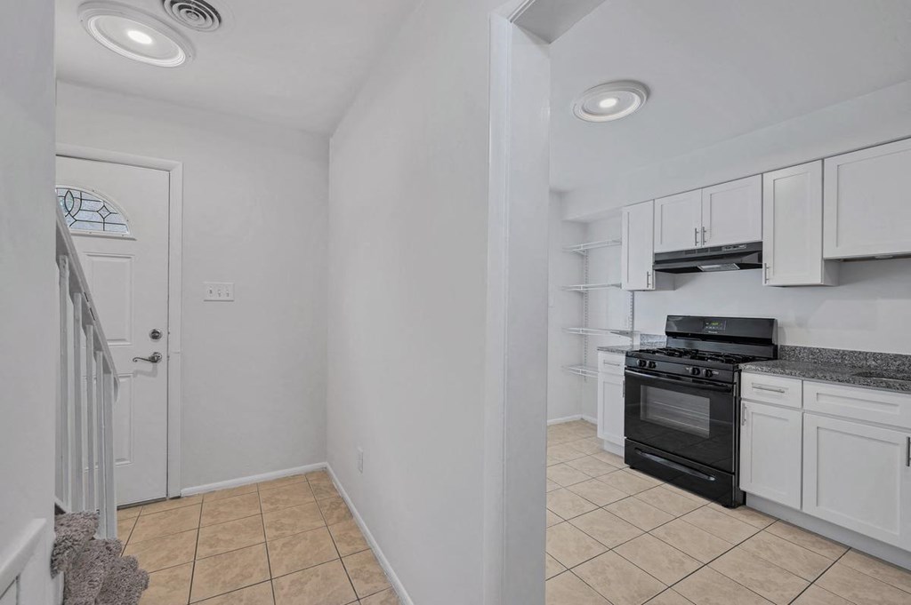 a kitchen with white cabinets and a black stove