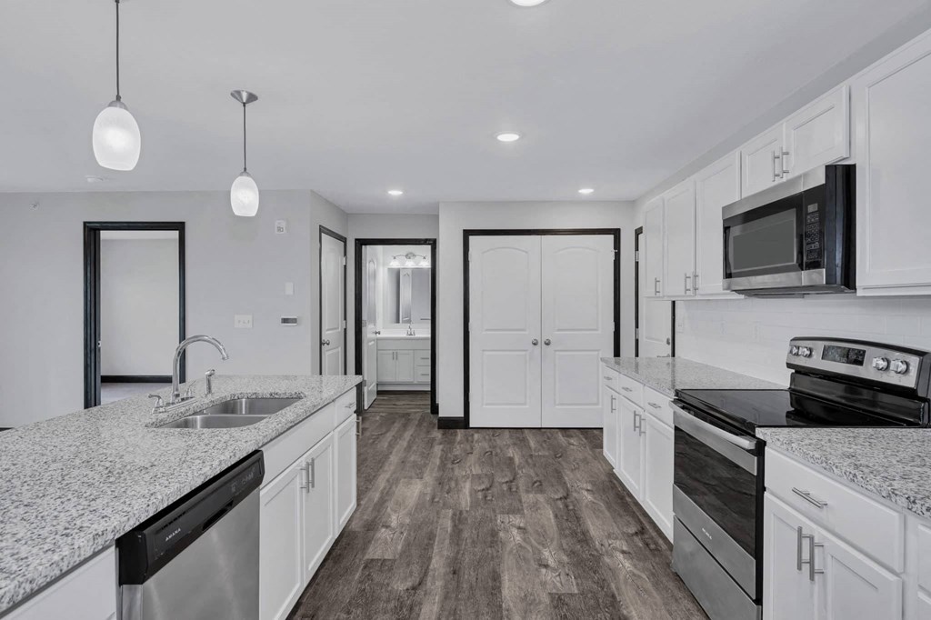 a kitchen with granite counter tops and white cabinets