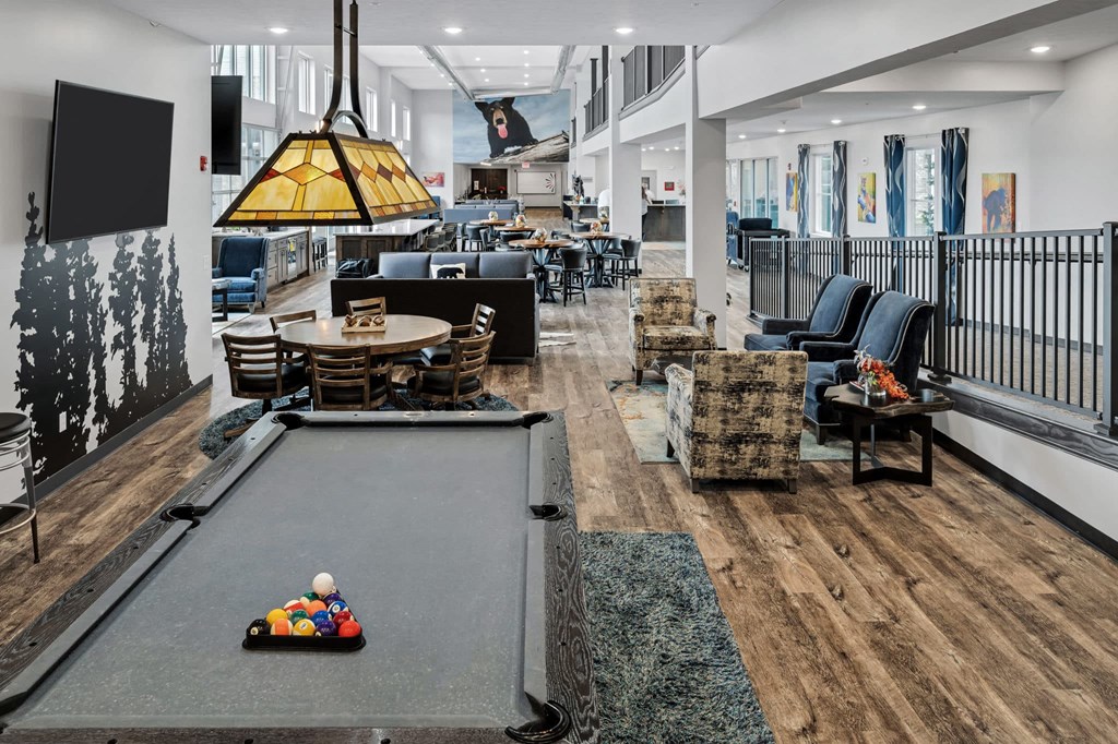 a communal area with a pool table and chairs