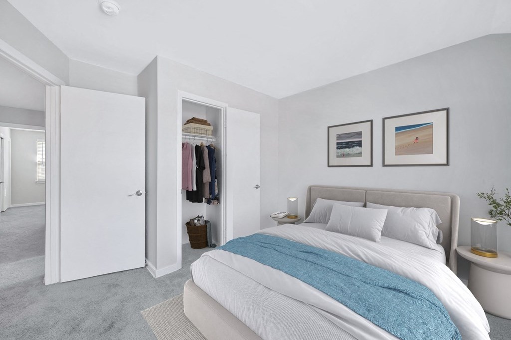 a bedroom with white walls and a white bed with a blue blanket
