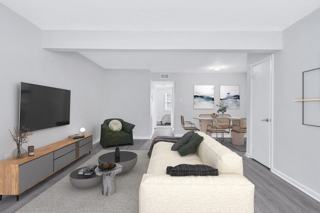 a living room with a large white couch and a large flat screen tv on the wall