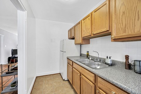 A kitchen with wooden cabinets and a granite countertop.