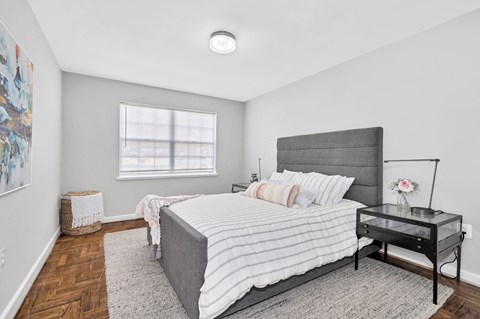 A bedroom with a large bed and a painting on the wall.