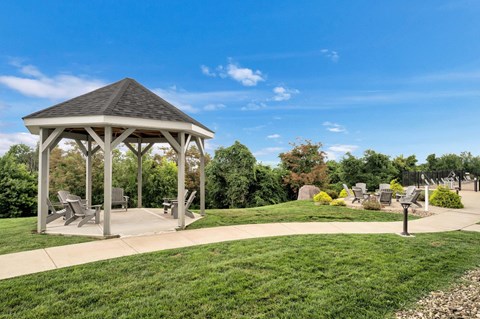 a pavilion with benches in a park on a sunny day