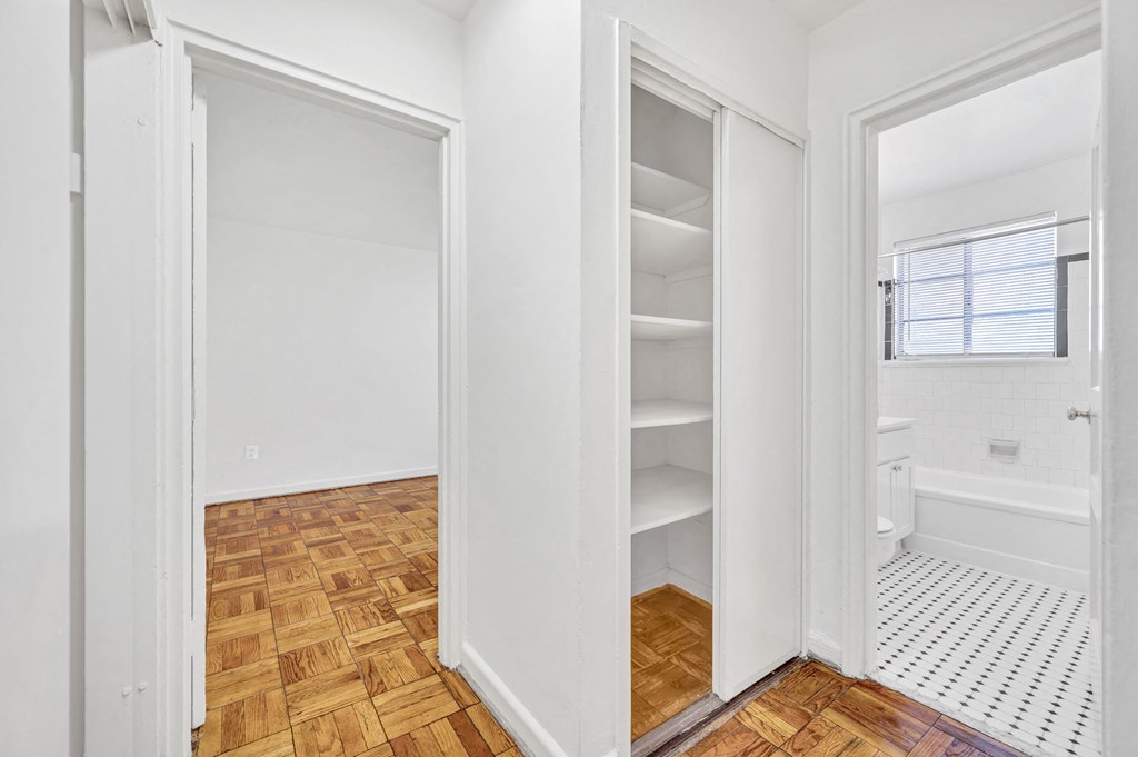a bedroom with a closet and a toilet and a window