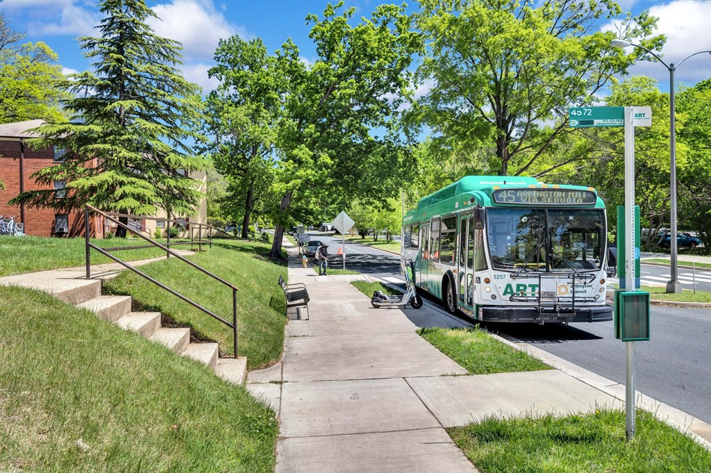 a green and white bus is parked at a bus stop