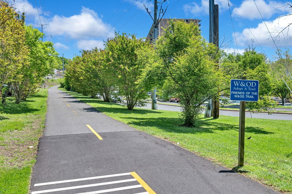 a sidewalk with a blue sign on the side of a road