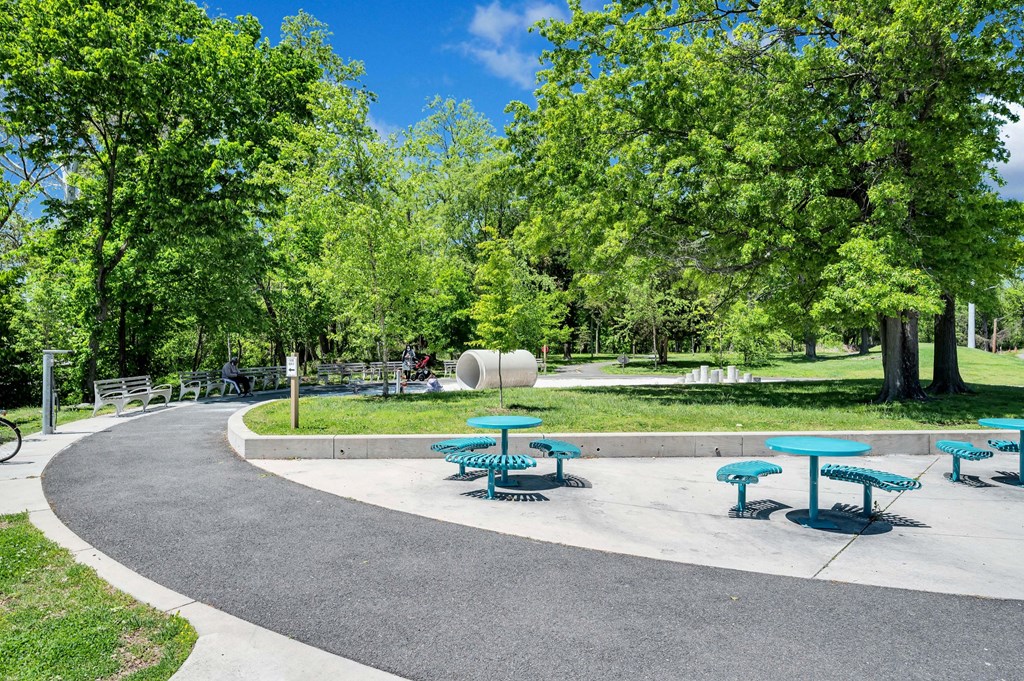 a park with picnic tables and a circular path with trees