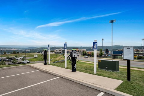 a row of electric parking meters in a parking lot