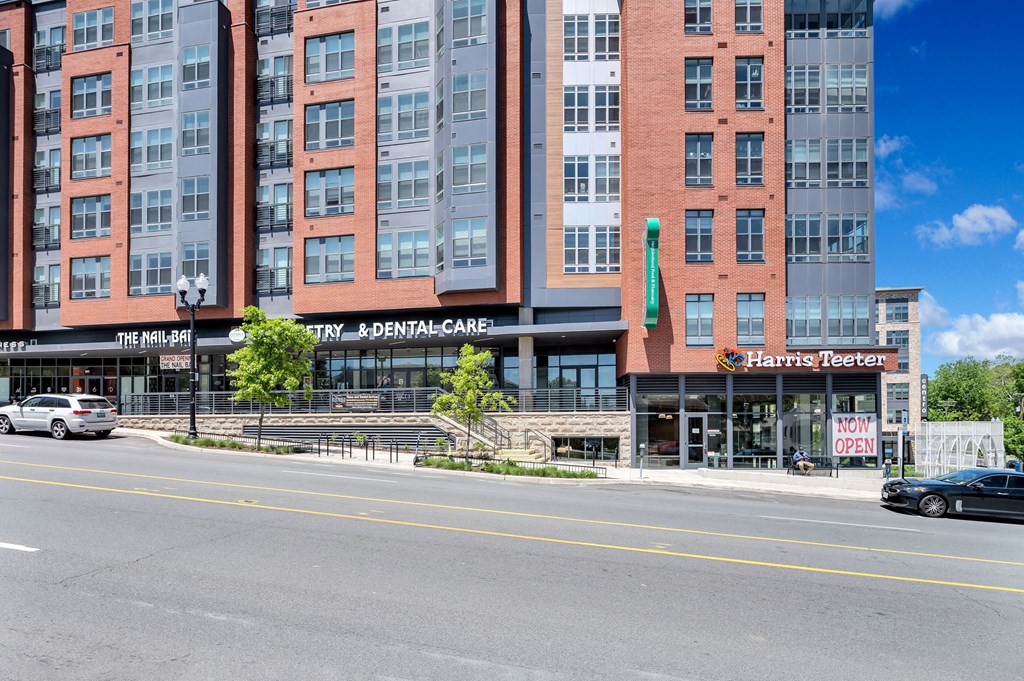 a view of a building from the street with cars parked in front of it