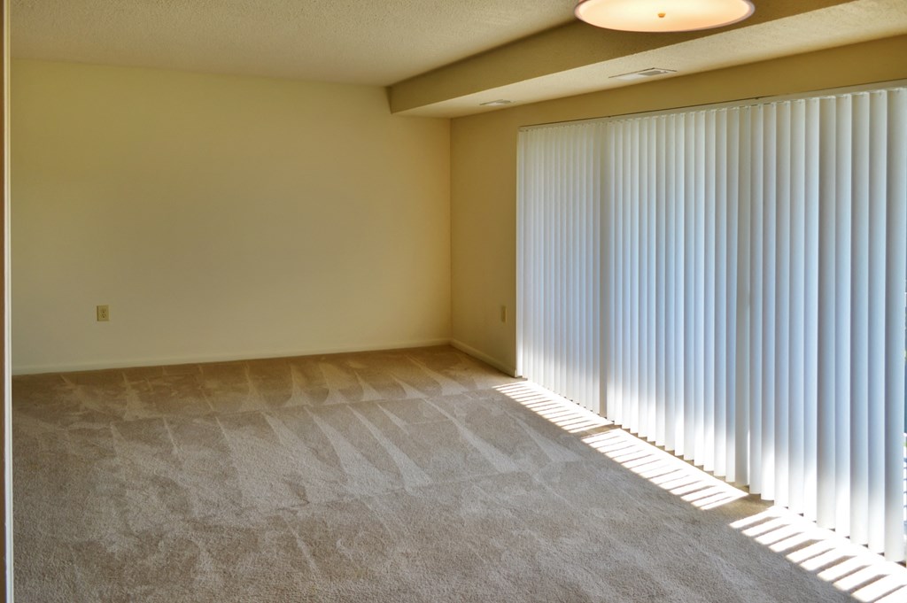 a living room with a large window with long blinds