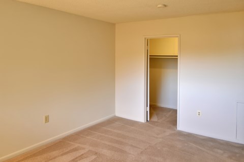 an empty room with a door to a closet
