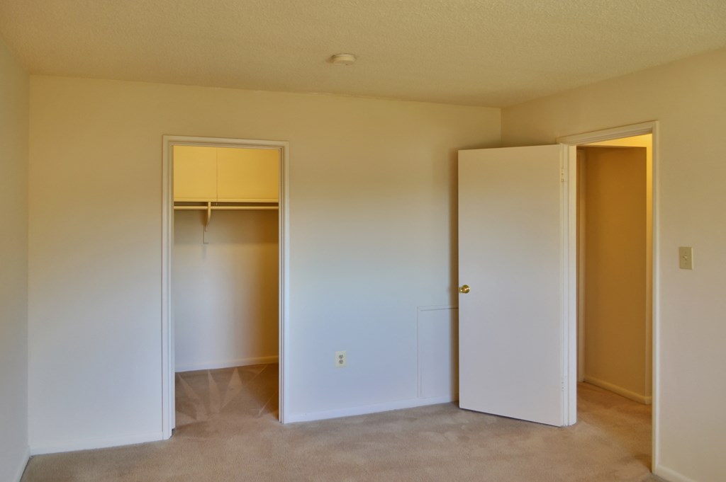 an empty room with a closet and an open door