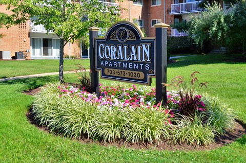 the sign is in the middle of a flower garden