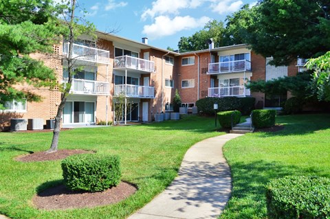 an exterior view of an apartment building with a sidewalk