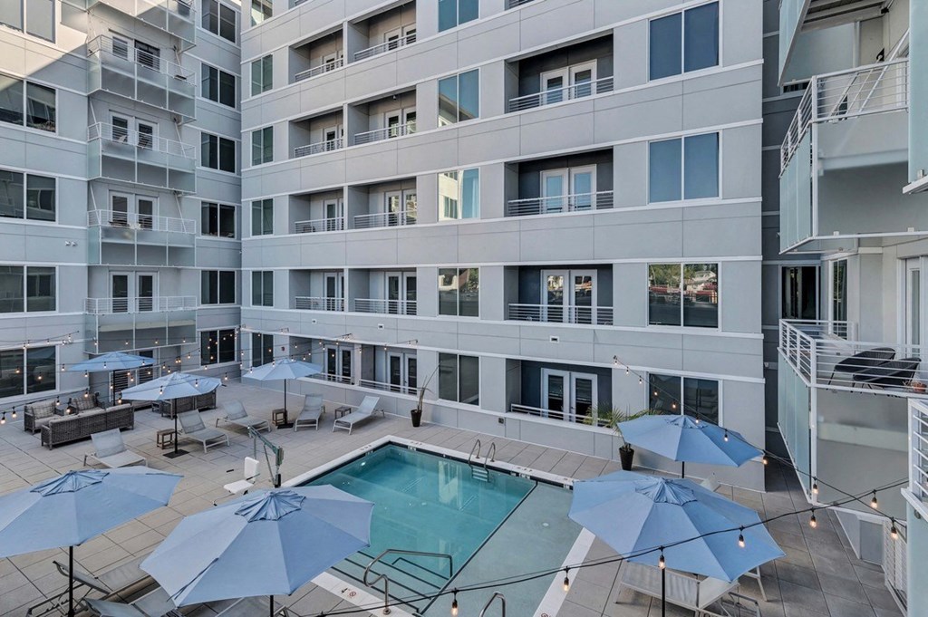 a swimming pool with umbrellas in front of a building