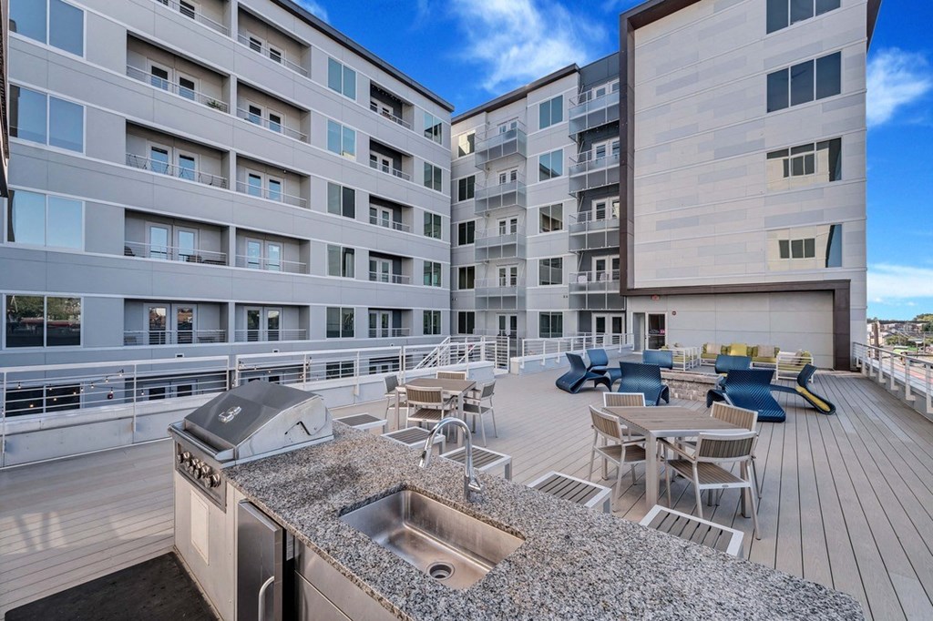 a large balcony with a sink and a table with chairs