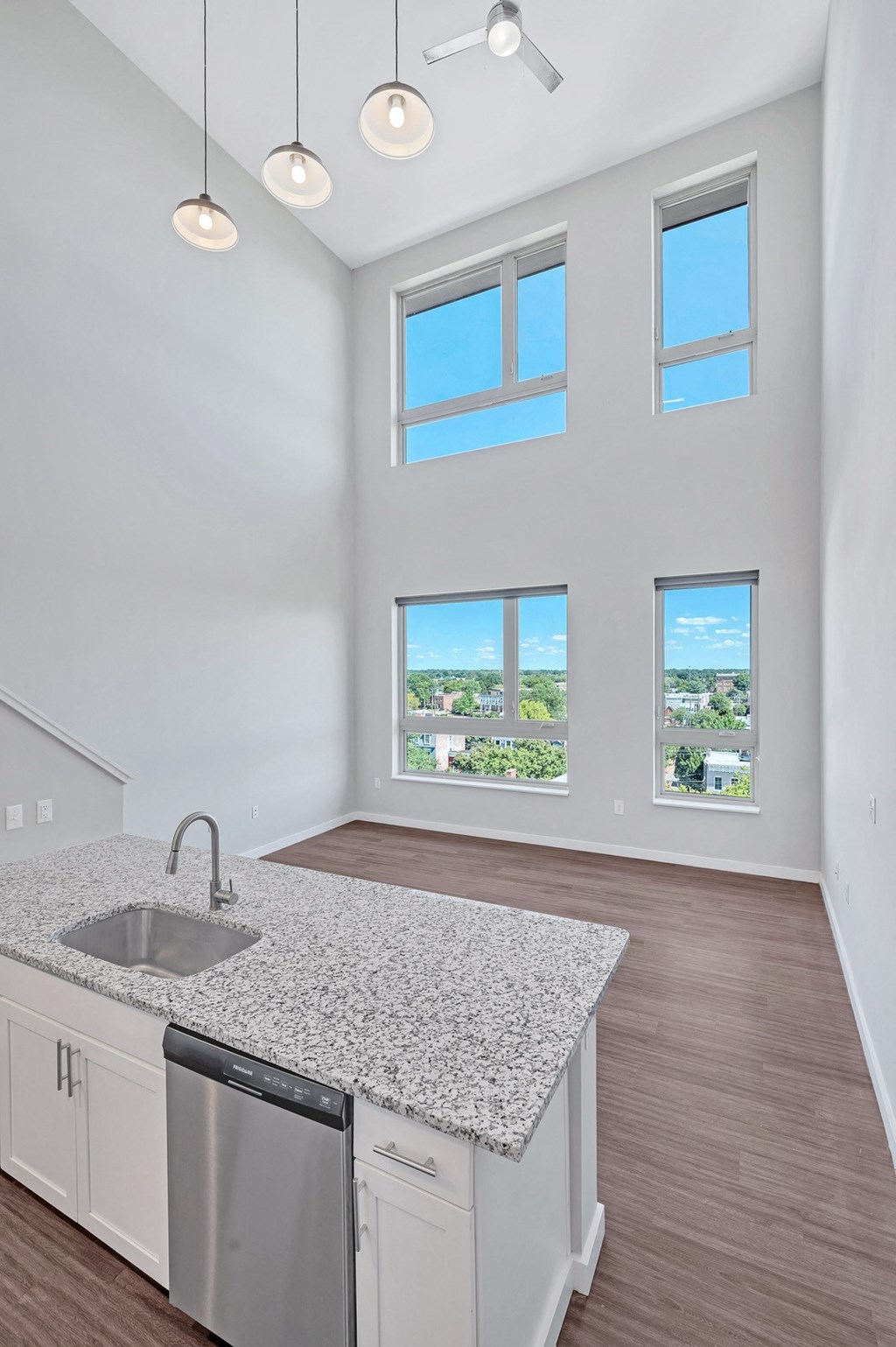an empty kitchen with a granite counter top and a sink