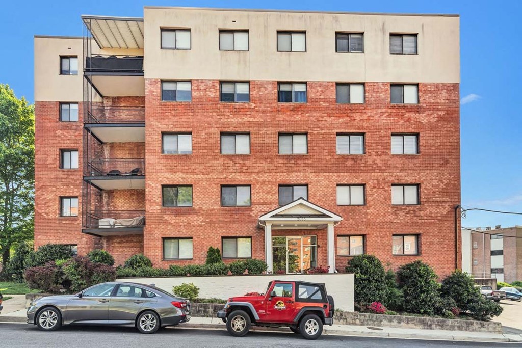 a red brick building with a red jeep parked in front of it