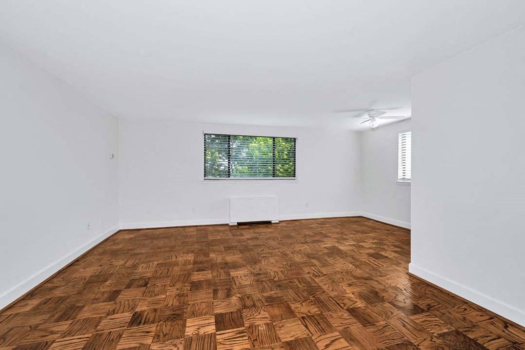 a bedroom with a window and a hardwood floor